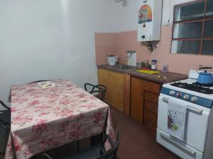 a small kitchen with a table and a stove at Alojamiento Las nenas a la vuelta del corsodromo in Gualeguaychú
