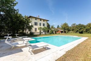 a swimming pool with two chairs and a house at Villa Amelia in Scarperia