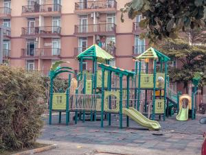a playground in front of a pink building at DL's crib in Lo-oc
