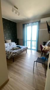 a bedroom with a bed and a chair and a desk at Room&Go Alba - Home Langhe in Alba