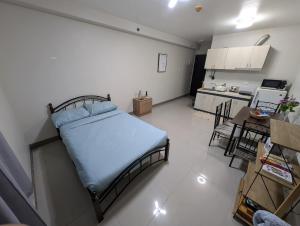 a small bedroom with a bed and a kitchen at DL's crib in Lo-oc