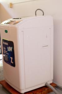a small white refrigerator sitting in a room at The Hollyoak - Vintage Charm with Modern Comforts in Denipitiya