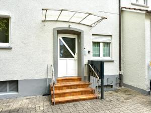 a white house with a white door and stairs at Appartement Turan in Friedrichshafen