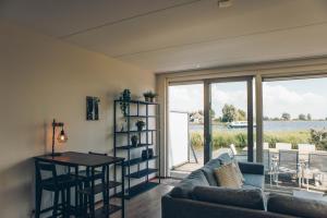 a living room with a couch and a table at Herenhuis geschakeld | 8 personen - Boutique Parc Pharshoeke in Heeg