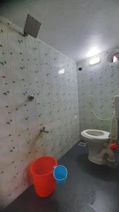 a bathroom with a toilet and a bucket at The Corner House by Liz Non Airconditioned in Mahabalipuram