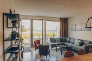 a living room with a couch and a table at Herenhuis geschakeld | 8 personen - Boutique Parc Pharshoeke in Heeg