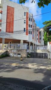 a building with a white fence in front of it at Apto bem localizado - com garagem in Salvador