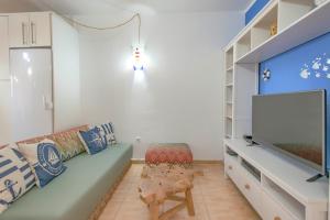 Una sala de estar con un sofá y un televisor de pantalla plana. en Sailor's Nest, en Callao Salvaje