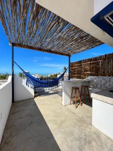 a patio with a hammock and a view of the ocean at Sunshine Kite Inn in Prea