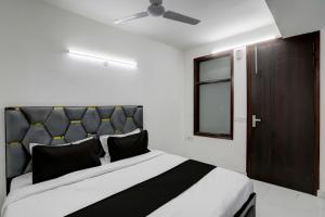 a bedroom with a black and white bed and a window at Collection O 24/7 Hotel in New Delhi