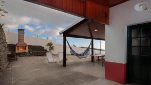 an outdoor patio with a hammock and a fireplace at Casa das Marias in Ponta do Pargo