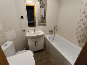 a bathroom with a sink and a toilet and a bath tub at Mieszkanie 41 in Częstochowa