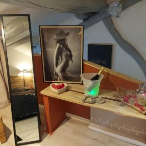 a counter with a mirror and a picture of a woman at Gite Marigot in Bazincourt-sur-Saulx