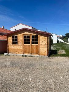 a wooden cabin with a large window in a driveway at Les Rochers de Vallières in Saint-Georges-de-Didonne