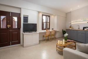 Una sala de estar con un sofá y una mesa con televisión. en Elysian Suite, en Rodas