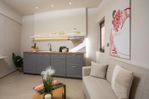 Una sala de estar con un sofá y una cocina. en Elysian Suite, en Rodas