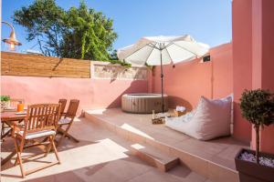 Un patio con una sombrilla y una mesa y sillas. en Elysian Suite, en Rodas