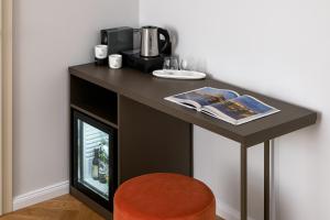 a black counter with a coffee maker and a magazine at The Bridge Residence by Little King in Prague