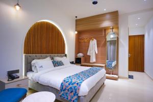 a bedroom with a large bed and a dressing room at The Elet in Amritsar