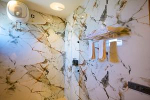 a bathroom with a marble wall with a shower at The Elet in Amritsar
