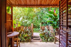 an open door to a garden with a wooden pathway at Pousada Vila Biribiri Trancoso in Trancoso