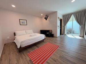 a bedroom with a white bed and a red rug at Beachside escape in Kuala Terengganu, Malaysia in Kampong Cherong Baru