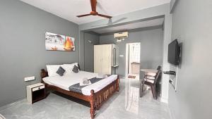 Un dormitorio con una cama, un televisor y una silla. en Jackson's Beach House Calangute, en Calangute