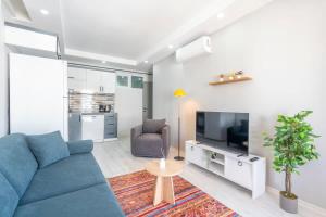 un soggiorno con un divano blu e una TV di Ethnic Chic2BR Concept Flat Near Oldtown AVM a Antalya (Adalia) Altre 15 foto