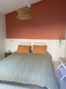 a bedroom with a large bed with two pillows at Chez Elsa et Camille in Aigues-Mortes