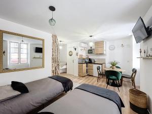 a bedroom with two beds and a table and a kitchen at O'BERCAIL in Tournon-sur-Rhône