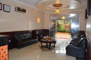 カンパラにあるSuper Paradise Hotelの革張りの椅子とテーブルが備わる待合室