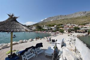 a beach with chairs and a bike on the sand at Apartments Boro in Dugi Rat
