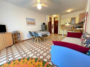 a living room with a couch and a table at Welcoming flat with pool view balcony in Porto Santa Margherita di Caorle