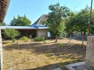 a garden with trees in front of a building at Rovshan's house in Sheki