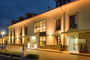 a large white building with a street at night at La Piconera Hotel & Spa in Ribadesella