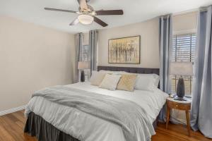 a bedroom with a bed with a ceiling fan at 4BR Game-Day Retreat - Foosball & Fire Pit in Fayetteville