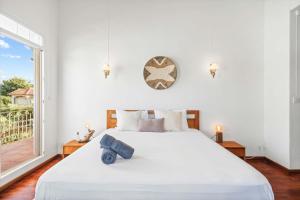 a white bedroom with a large bed and a window at Serenity Bay - Perfect Tropical Stay in Pointe aux Cannoniers