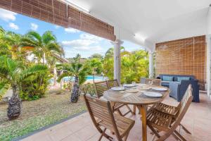 a dining room with a table and chairs on a patio at Serenity Bay - Perfect Tropical Stay in Pointe aux Cannoniers