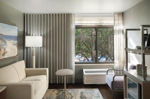 a living room with a couch and a window at Hotel Indigo East End by IHG in Riverhead