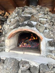 a stone oven with a fire in it at Toneh Villa in Lernarot