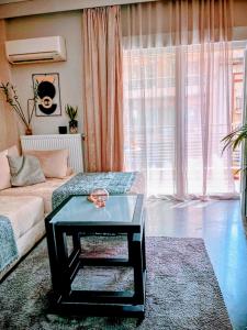 塞萨洛尼基Mitropolews 55 apartment的客厅里有一张沙发和一张桌子。