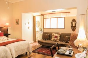 ein Schlafzimmer mit einem Bett, einem Sofa und einem Tisch in der Unterkunft Beau & I in Graaff-Reinet