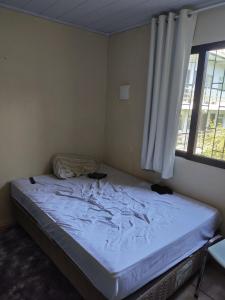 a bedroom with a bed in a room with a window at Ferreira hostel in Florianópolis
