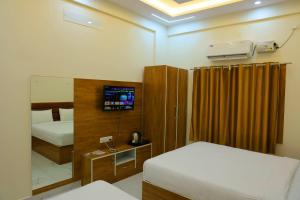 a bedroom with two beds and a tv in it at Hotel jetway in Muthugadahalli