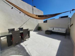 a patio with a table and chairs and a couch at Appartement lumineux à deux pas du port, avec terrasse in La Ciotat