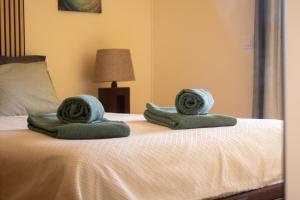 a bed with two towels on top of it at Dunes Apartment - Near the Beach in Guia +13 photos