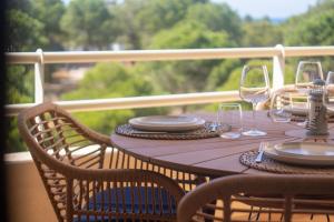 a wooden table with wine glasses on a balcony at Dunes Apartment - Near the Beach in Guia