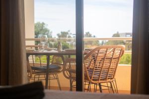 a table with chairs and wine glasses on a balcony at Dunes Apartment - Near the Beach in Guia