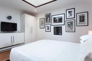 a bedroom with a white bed and pictures on the wall at Roedonis SoHo in New York