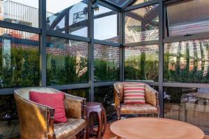 two chairs and a table in a room with windows at Roedonis SoHo in New York +4 photos